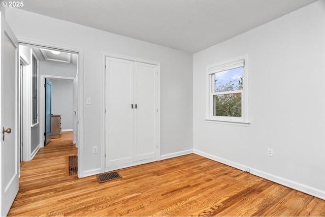 unfurnished bedroom featuring a closet and light wood-type flooring