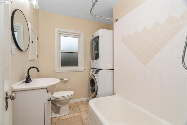 bathroom featuring toilet, tile patterned floors, vanity, and stacked washing maching and dryer