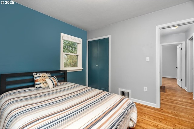 bedroom with light hardwood / wood-style floors and a closet