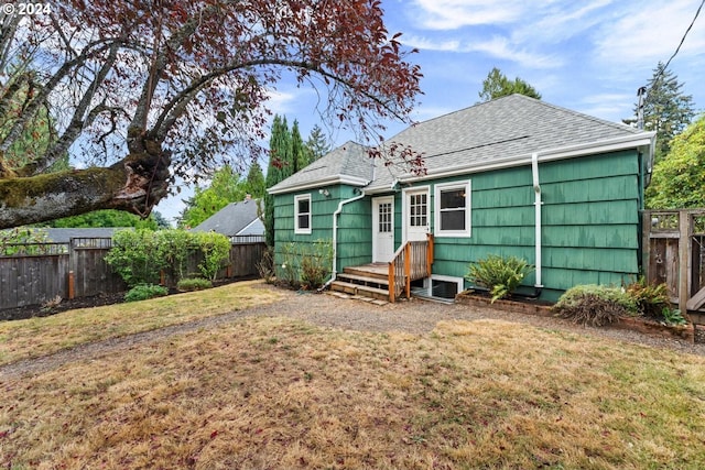 rear view of house featuring a lawn