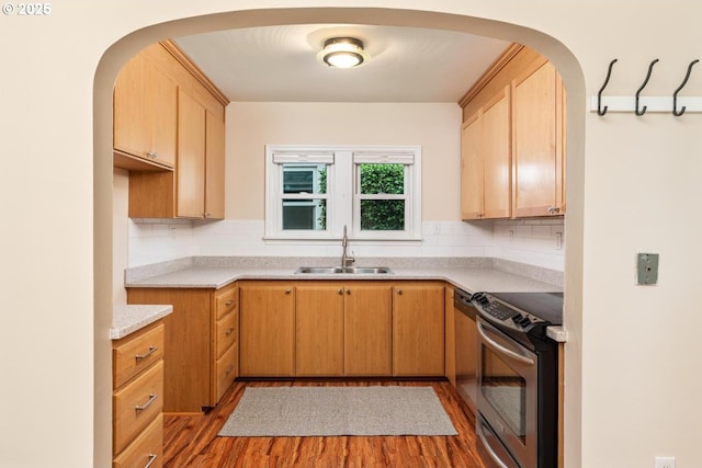 kitchen featuring light brown cabinetry, sink, stainless steel electric range, hardwood / wood-style floors, and decorative backsplash