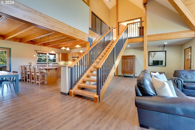 stairs featuring wood-type flooring, wood ceiling, and beamed ceiling