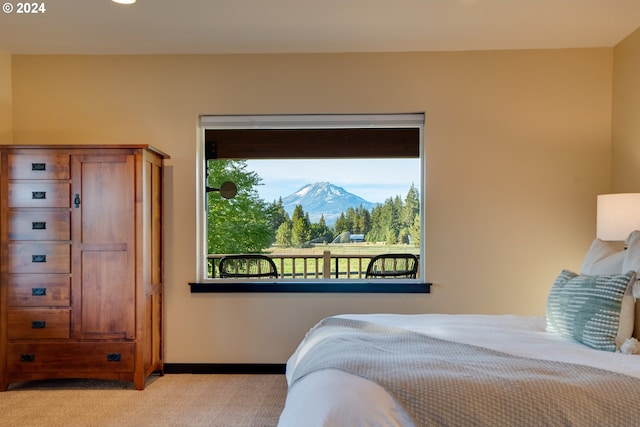 bedroom with a mountain view and light colored carpet