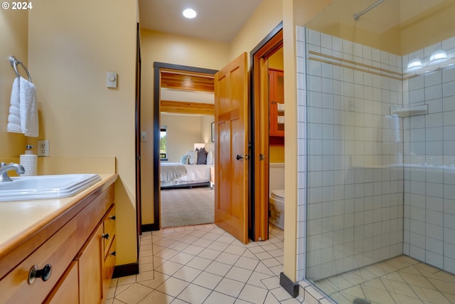 bathroom with vanity, tile patterned floors, toilet, and tiled shower