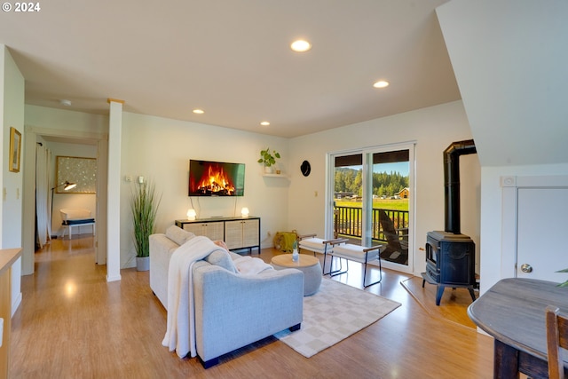 living room with a wood stove and light wood-type flooring