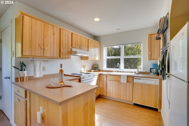 kitchen featuring white appliances, kitchen peninsula, light brown cabinets, and light hardwood / wood-style floors