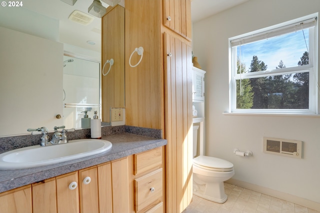 bathroom featuring vanity, toilet, and heating unit