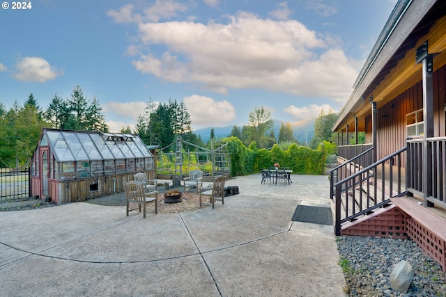 view of patio featuring a mountain view, a shed, and a fire pit