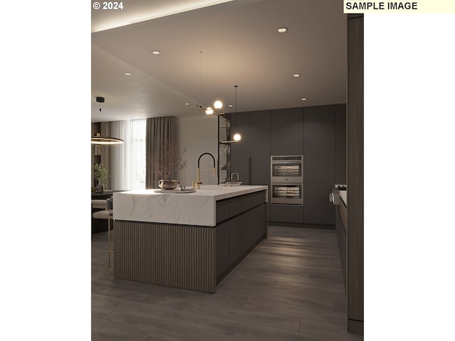 kitchen with hardwood / wood-style floors, a large island, pendant lighting, and gray cabinets