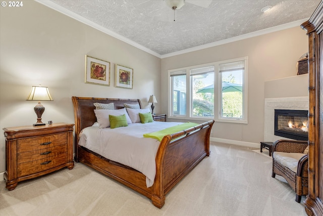 bedroom with ceiling fan, light colored carpet, a textured ceiling, and a fireplace