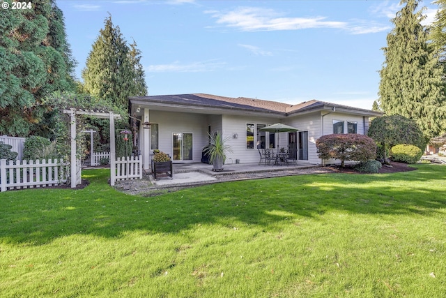 back of property with a lawn and a patio area