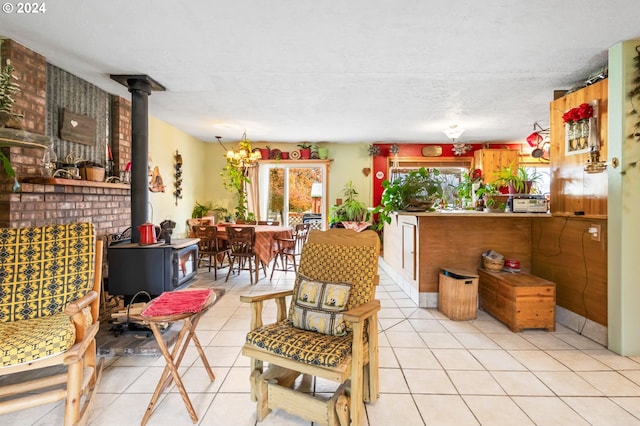 interior space featuring a wood stove, a notable chandelier, light tile patterned flooring, and a textured ceiling