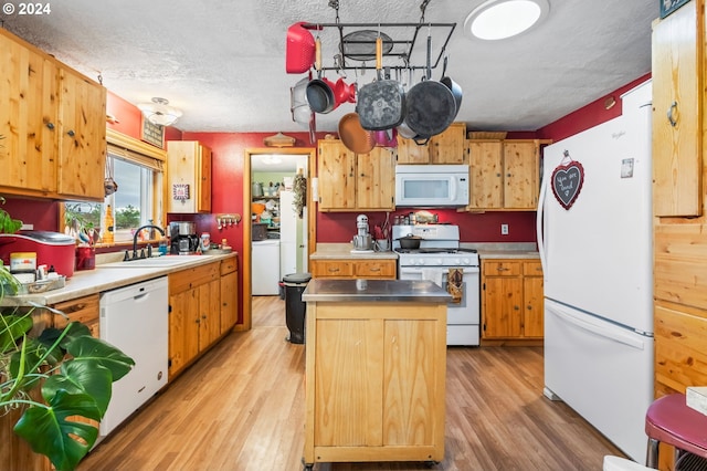 kitchen with sink, a textured ceiling, washer / clothes dryer, white appliances, and light hardwood / wood-style flooring