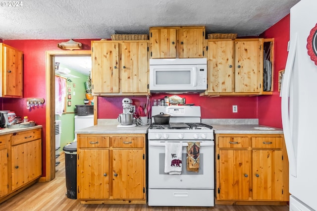 kitchen featuring white appliances, a textured ceiling, and light hardwood / wood-style floors