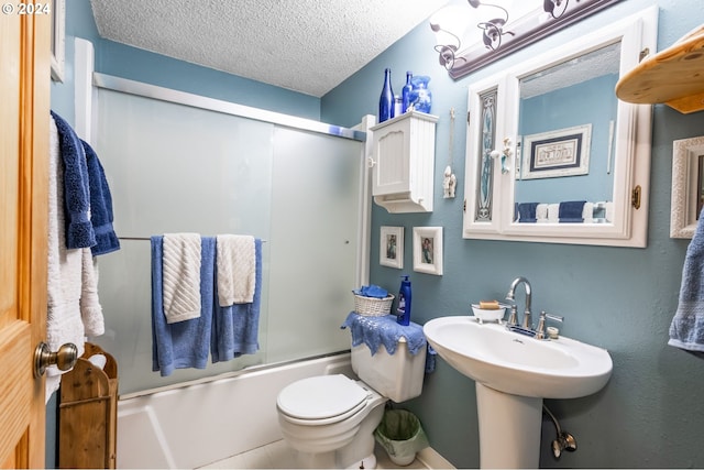 bathroom featuring shower / bath combination with glass door, a textured ceiling, and toilet