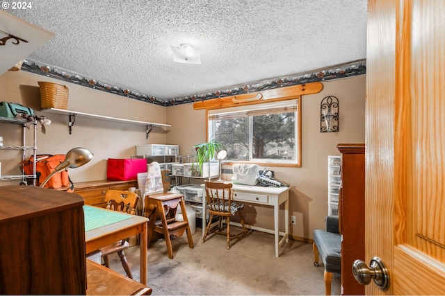 carpeted home office featuring a textured ceiling