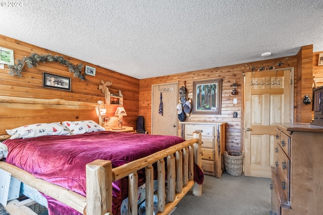 bedroom with carpet, wood walls, and a textured ceiling