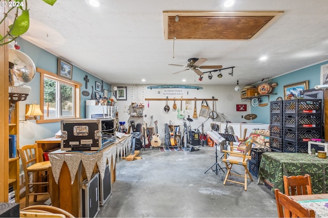 misc room featuring concrete flooring, ceiling fan, and a workshop area