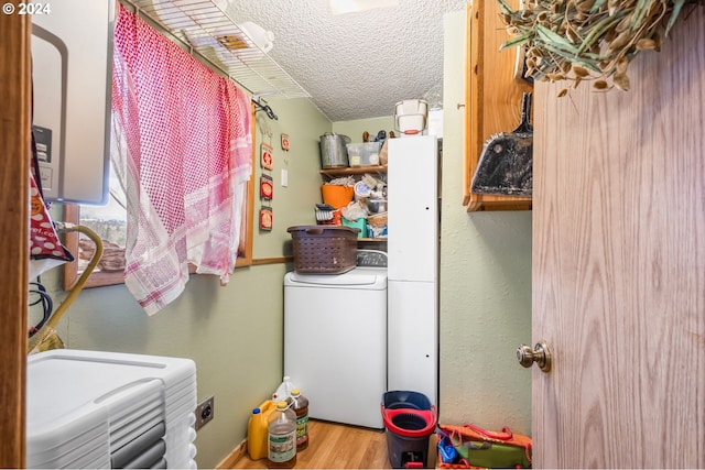 washroom featuring independent washer and dryer, a textured ceiling, and hardwood / wood-style flooring