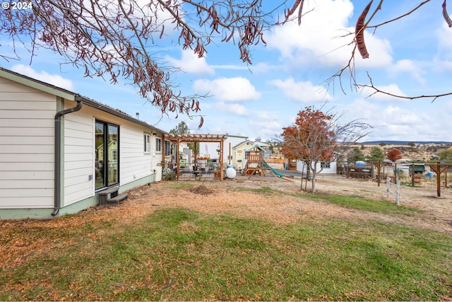 view of yard featuring a playground and a pergola