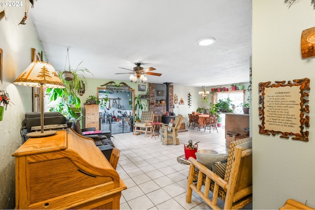 tiled living room featuring a wood stove and ceiling fan