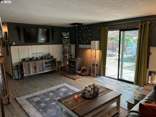 living room with a wood stove, hardwood / wood-style floors, and a textured ceiling