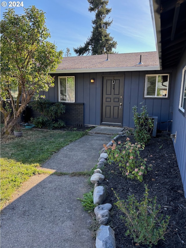 view of exterior entry with a yard