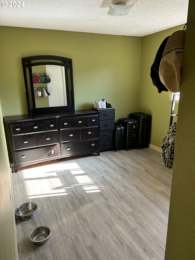 bedroom with light hardwood / wood-style flooring and a textured ceiling