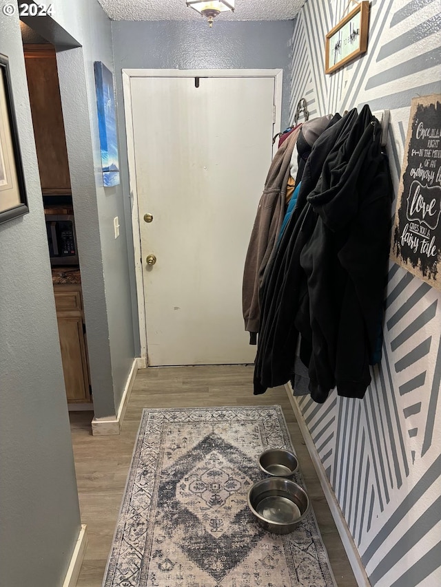 entryway with a textured ceiling and light wood-type flooring