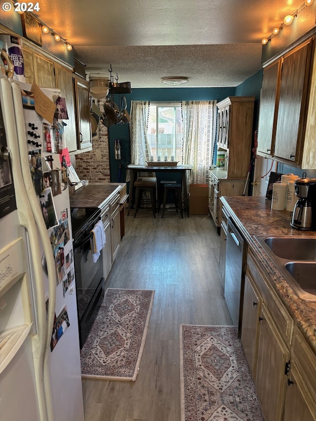 kitchen featuring black electric range, dark hardwood / wood-style floors, a textured ceiling, and white refrigerator