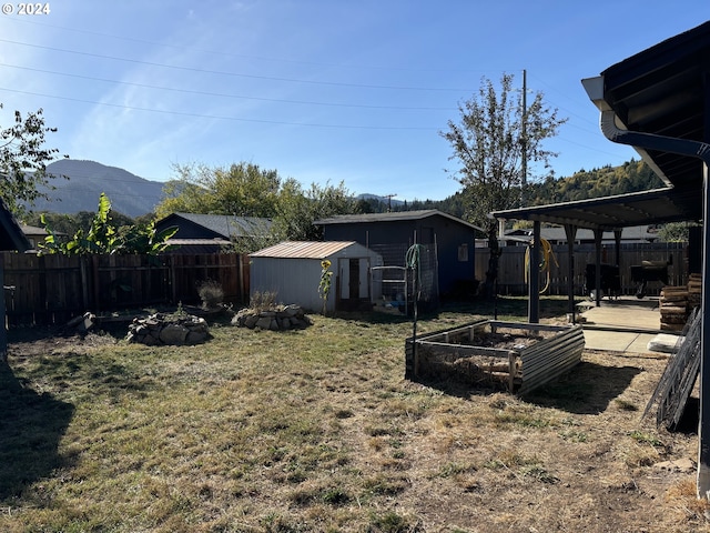 view of yard featuring a mountain view, a pergola, and a storage shed