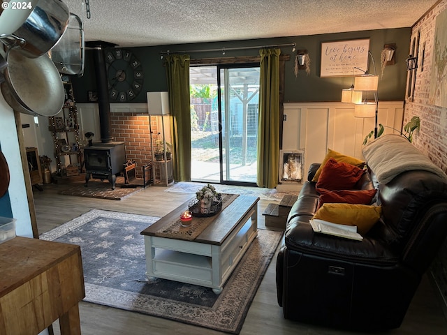 living room featuring a textured ceiling, hardwood / wood-style flooring, and a wood stove