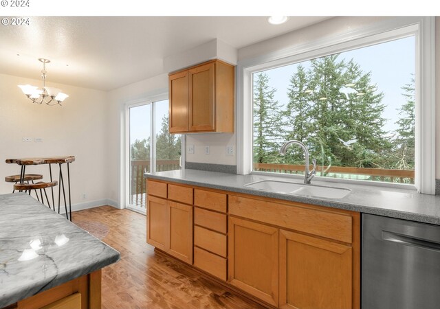 kitchen featuring dishwasher, a wealth of natural light, sink, and light hardwood / wood-style floors