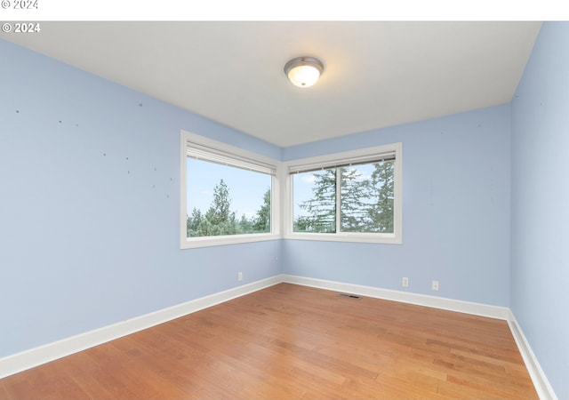 unfurnished room with visible vents, baseboards, and wood finished floors