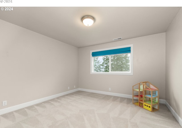 spare room featuring baseboards, visible vents, and light colored carpet