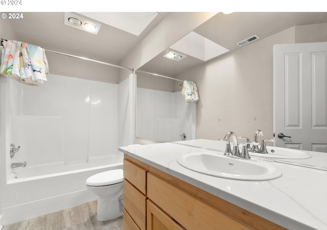 full bathroom with bathtub / shower combination, toilet, wood finished floors, vanity, and visible vents