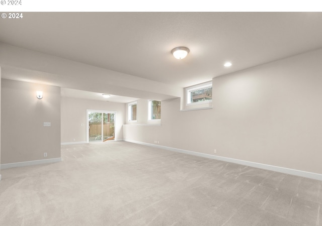 basement featuring recessed lighting, light colored carpet, and baseboards