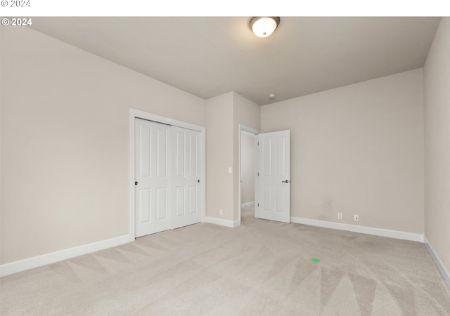 unfurnished bedroom with light colored carpet and baseboards