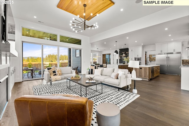 living room with dark hardwood / wood-style flooring, a chandelier, and sink