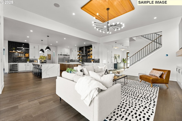 living room with dark hardwood / wood-style flooring, wine cooler, and a notable chandelier