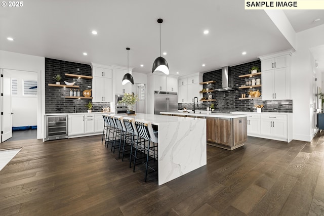 kitchen featuring wine cooler, white cabinets, a spacious island, and appliances with stainless steel finishes