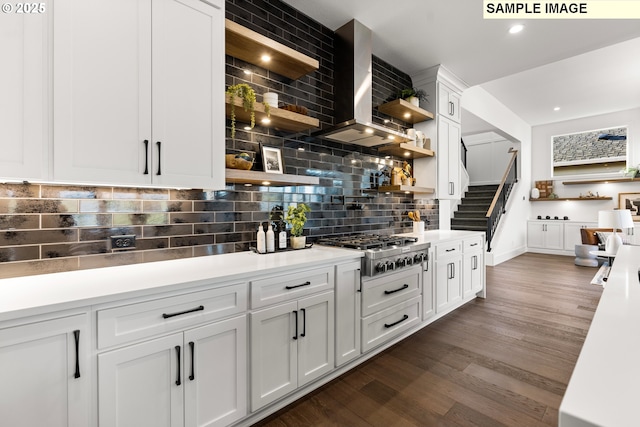 kitchen with backsplash, wall chimney exhaust hood, white cabinets, dark hardwood / wood-style floors, and stainless steel gas stovetop