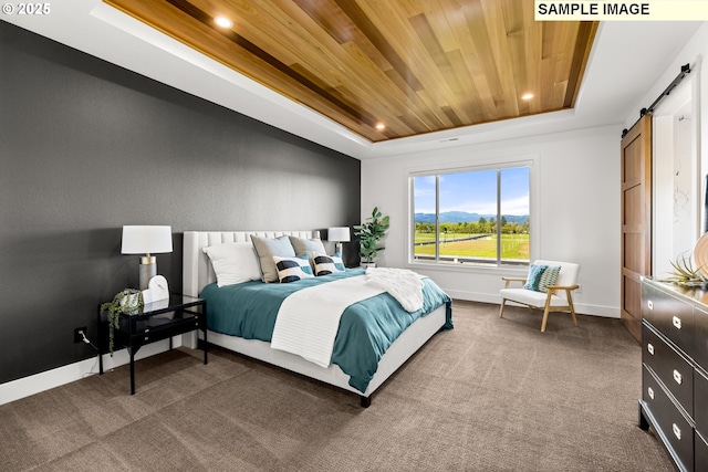 carpeted bedroom with a raised ceiling, a barn door, and wooden ceiling