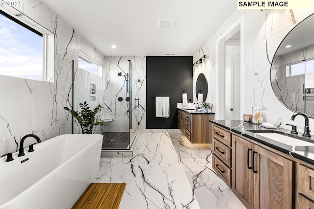 bathroom with vanity and shower with separate bathtub