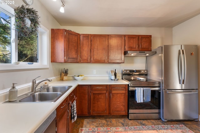 kitchen with stainless steel appliances, track lighting, and sink