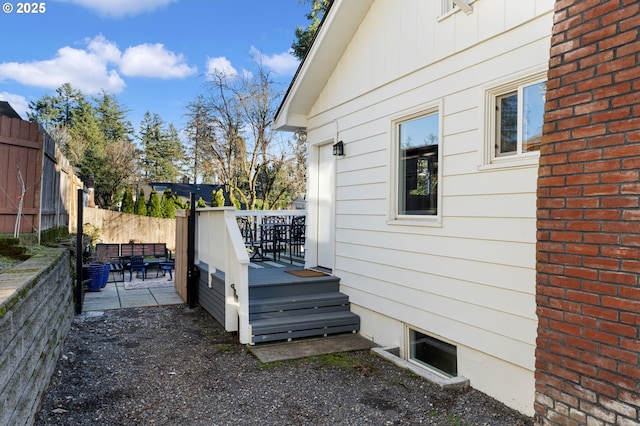 view of side of home featuring a patio area and a deck