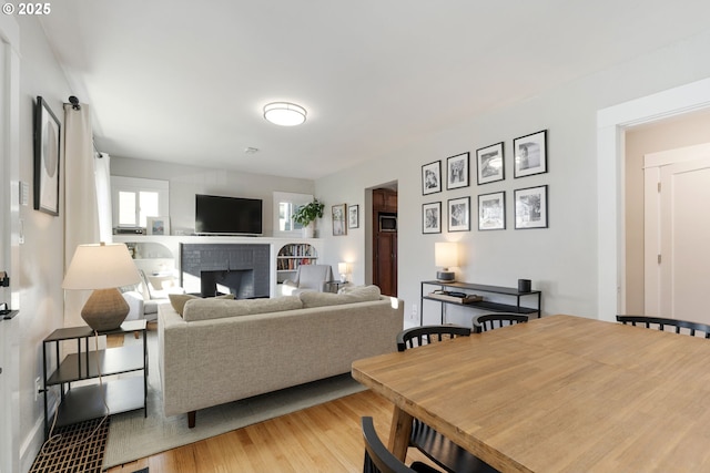 living room with hardwood / wood-style flooring and a brick fireplace