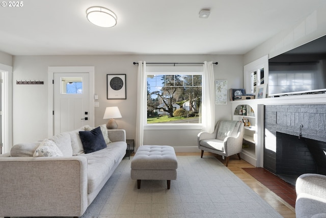 living room featuring a fireplace, a healthy amount of sunlight, and light hardwood / wood-style floors