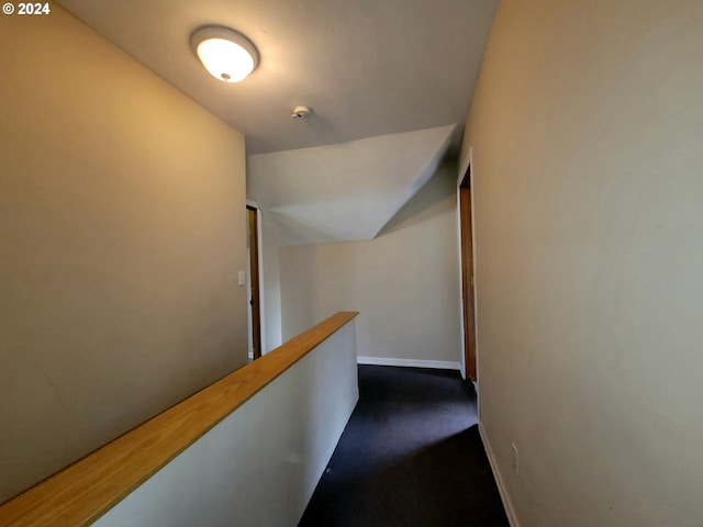 hall featuring dark colored carpet