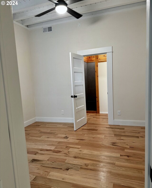 empty room featuring ceiling fan, ornamental molding, and light wood-type flooring